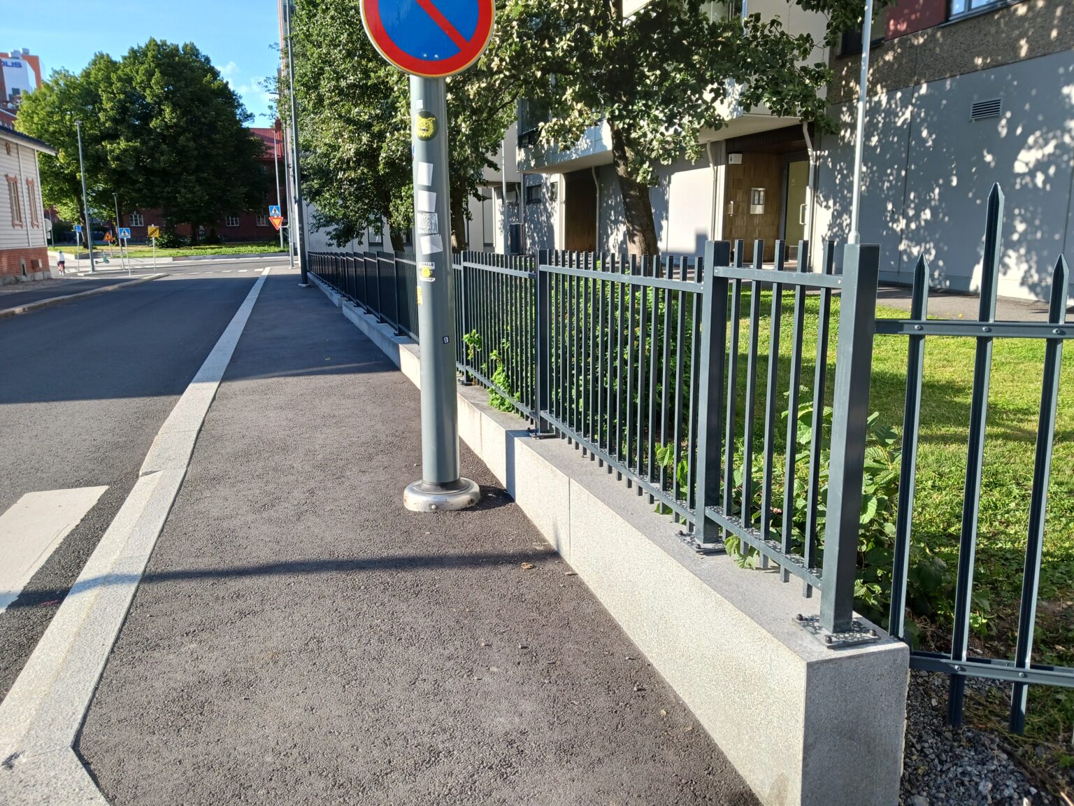 Metalliaita kerrostalon pihalla. Valmistamme suunnitelmien mukaiset metalliaidat, -portit sekä muut metallirakenteet.